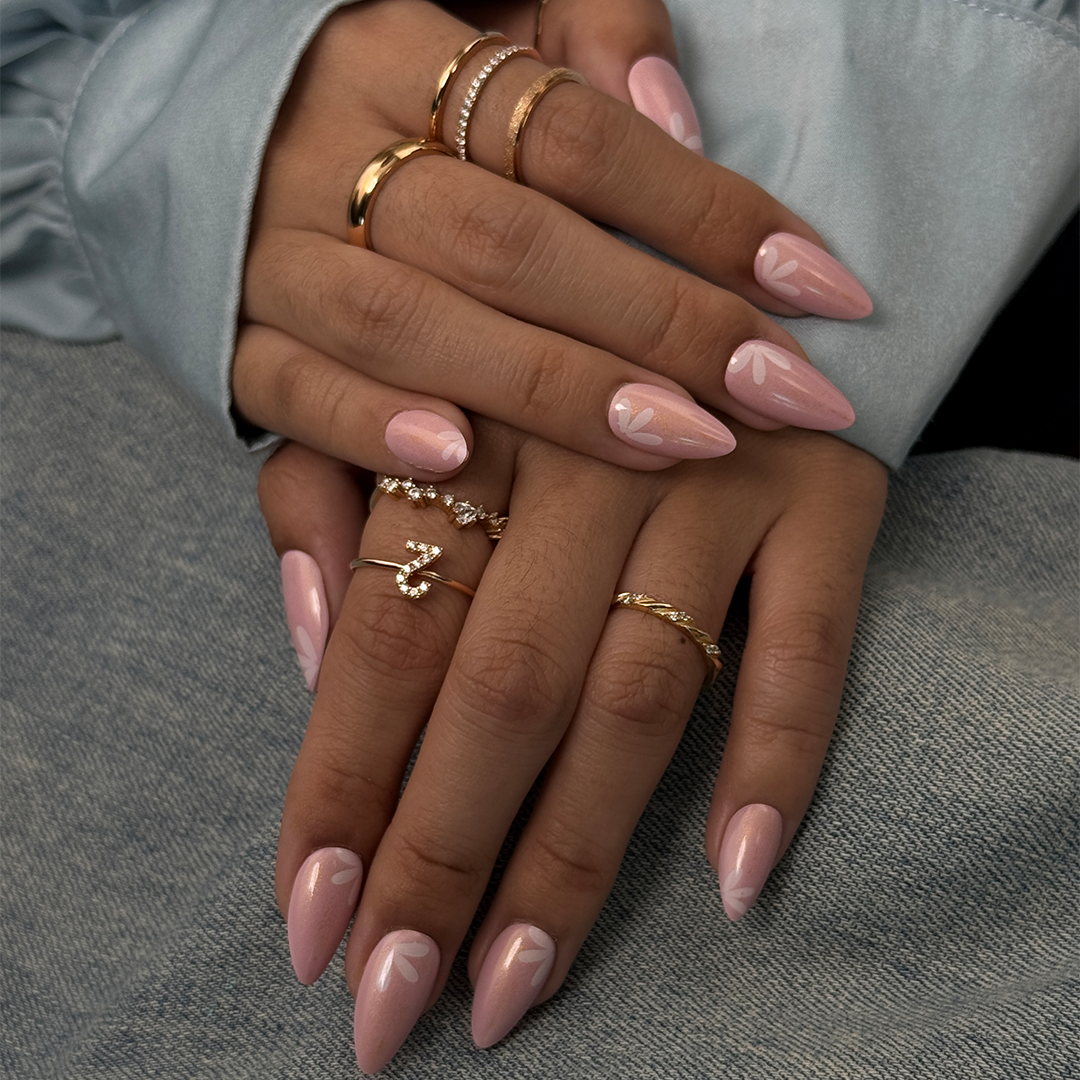 Fincloset soft pink natural almond-shaped press-on nails with yellow shimmer, fine glitter, and dainty white floral designs, creating a fresh, feminine, and radiant spring-inspired manicure.