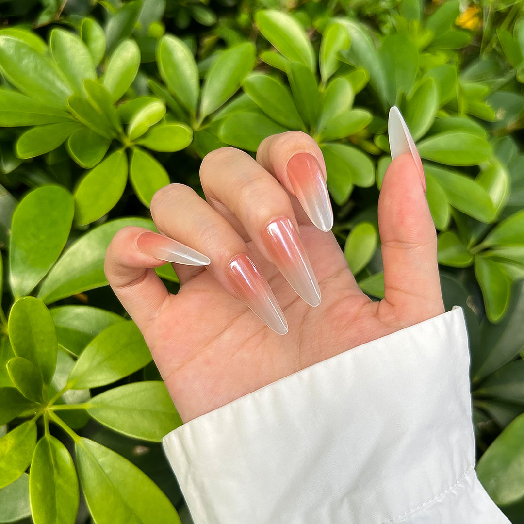 Stiletto-shaped press-on nails with a satin finish, featuring a nude-to-white gradient. Elegant and soft style for a refined look.