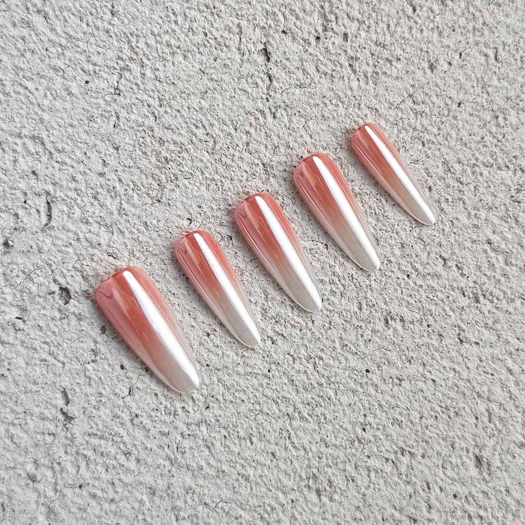 Stiletto-shaped press-on nails with a satin finish, featuring a nude-to-white gradient. Elegant and soft style for a refined look.