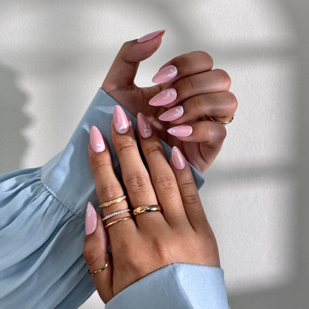 Fincloset soft pink natural almond-shaped press-on nails with yellow shimmer, fine glitter, and dainty white floral designs, creating a fresh, feminine, and radiant spring-inspired manicure.