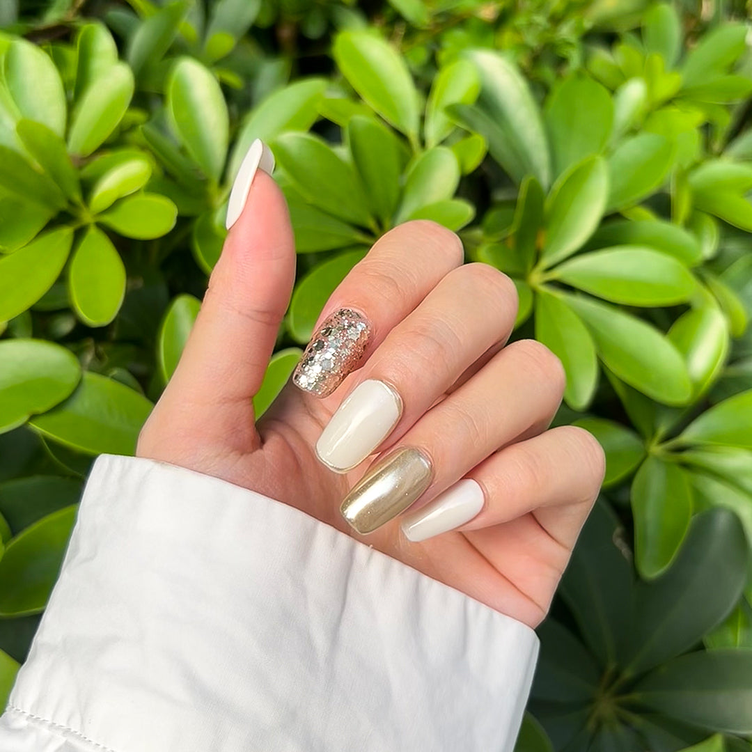 Ivory Luxe handmade square-shaped press-on nails in ivory and gold with sparkling gold glitter accents