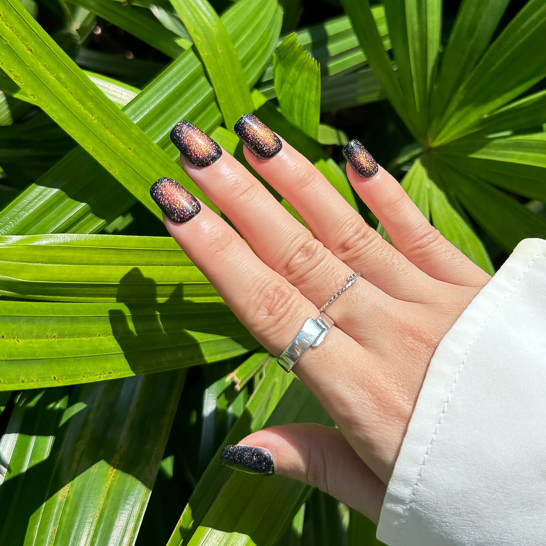 Fireworks handmade short square press-on nails with black base and multicolor cat-eye glitter, resembling fireworks in the dark night