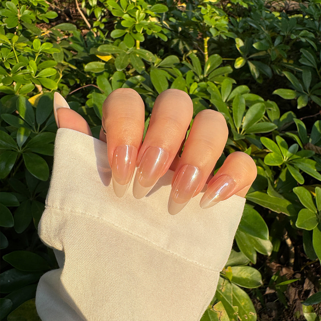 Glossy satin almond-shaped French tips press-on nails in nude pink, offering a delicate and chic finish.