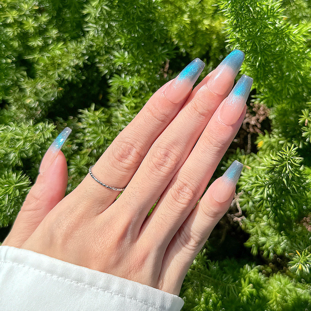 Handmade long coffin-shaped French press-on nails with blue gradient cat-eye effect and subtle sparkles, offering a minimalist and elegant style.