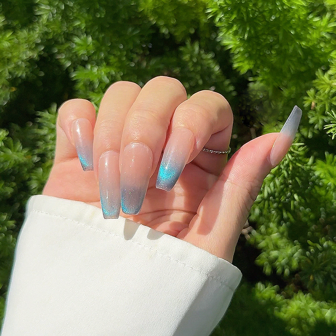 Handmade long coffin-shaped French press-on nails with blue gradient cat-eye effect and subtle sparkles, offering a minimalist and elegant style.