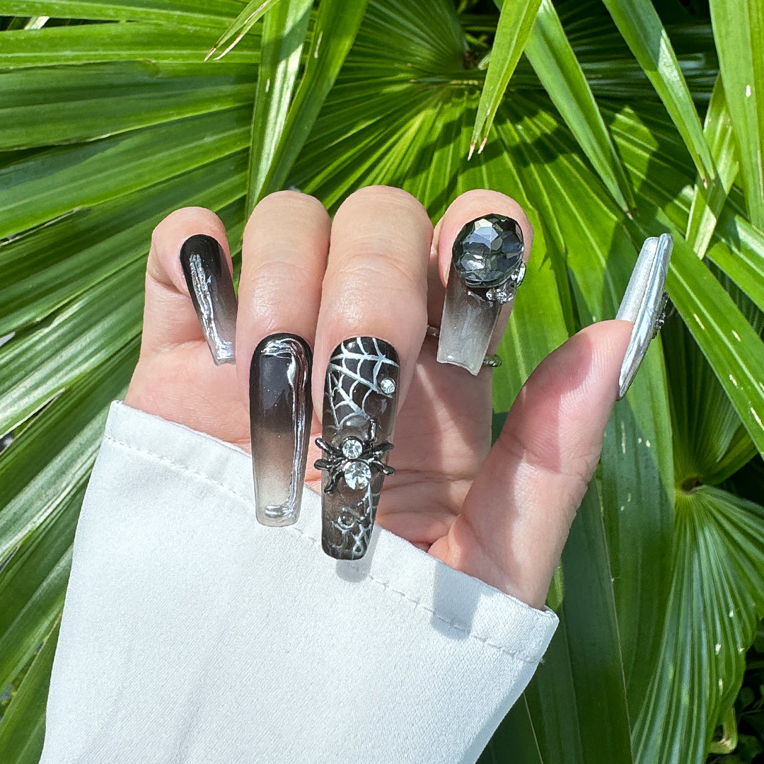 Glossy gradient black Long coffin-shaped press-on nails with cool spider and rhinestone details.