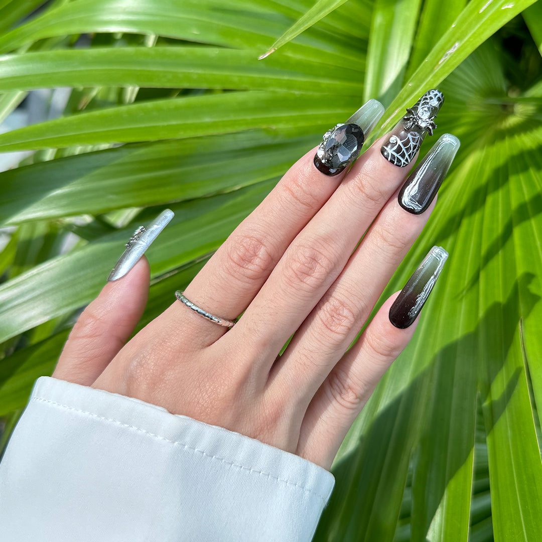 Glossy gradient black Long coffin-shaped press-on nails with cool spider and rhinestone details.