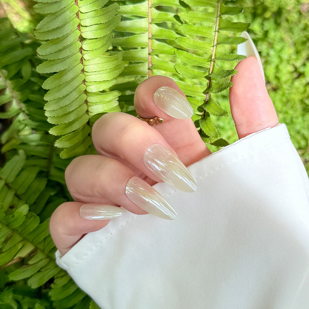 Glossy almond-shaped satin press-on nails in creamy white for a soft, elegant look.