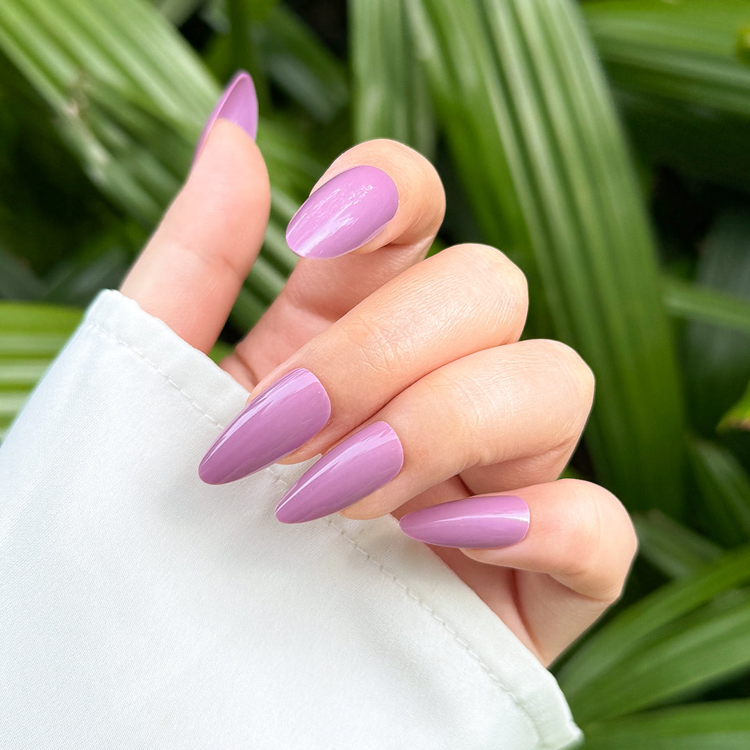 Glossy almond-shaped press-on nails in a bold purple shade, perfect for making a statement.